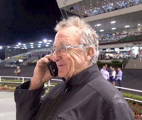 Trainer Ray Green takes a call from owner Merv Butterworth in the winners’ circle.