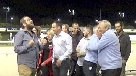 Carl Officer, left, looks to the heavens amid the celebrations while syndicate member Stu Cappie gives John Street a hug