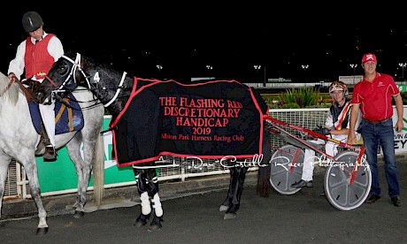 Trainer Al Barnes, driver son Hayden and Northview Hustler, wearing the rug Barnes coveted so much. PHOTO: Dan Costello.