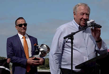 John Street gives the acceptance speech with co-owner Neville McAlister holding the cup.